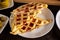 Pizza waffles, piffle. Waffles stuffed with sausage, cheese, tomatoes on a plate