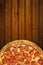 Pizza on wooden background. Top view of hot pizza pepperoni closeup with mozzarella cheese. Banner flat lay with copy