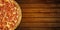 Pizza on wooden table. Top view of hot pizza pepperoni closeup with mozzarella cheese. Banner flat lay with copy space