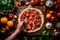 Pizzaiolo stretching out pizza dough on a wooden countertop, surrounded by fresh ingredients like tomatoes, basil, and mozzarella