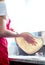 Pizzaiolo twirls and tosses pizza dough.