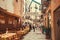 Pizzeria and trattoria signs for customers on narrow street with people walking past