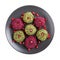 Pkhali or Phali on black plate isolated on white. Set of multicolored vegan balls from beets, spinach, ground nuts and herb.