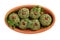 Pkhali or Phali in clay bowl ketsi isolated on white. Vegan balls from spinach, ground nuts and herb. Traditional  Georgian