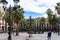 Placa Reial, shaded by palms and cooled by a fountain. Colorful lamp posts known as GaudÃ¬ first opera in the center. Barcelona