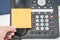 Place mock up sticky note on IP phone in office