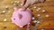 Place a yen coin into a pink piggy bank on a wooden table
