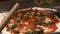Placing Basil Pesto On Pizza Crust