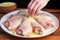 placing chicken legs basted with garlic butter on a patterned plate