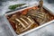 Plaice or Flounder flat fish baked in a tomato sauce in baking tray. White background. Top view