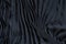 Plain black fabric pleated with lines as a background