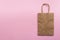 Plain blank brown paper bag on a pink background right, empty for own design