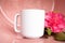 Plain blank white 11oz cup on a pink shiny surface with a pink rose flower