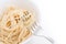 Plain cooked spaghetti pasta in white bowl and on fork, on white background.