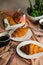 Plain Croissant served on wooden board with cup of black coffee isolated on napkin with knife and fork side view of french