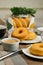 Plain Donuts with dip and cup of coffee isolated on napkin side view of baked food breakfast on table