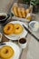 Plain Donuts with dip and cup of coffee isolated on napkin side view of baked food breakfast on table