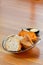 Plain fresh baguette bread slices in plate on wooden table with butter behind