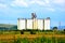 Plain with grains in the harvesting time. Grain silo