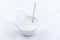 Plain Greek Yogurt in cup with spoon on white