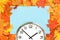 Plain wall clock in the center on red fall foliage