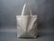 A plain white Blank tote canvas bag isolated on a gray backdrop