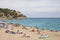 Plajan on the Costa Brava and city beach in Lloret de Mar, Spain. Sand and sea waves.