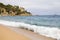 Plajan on the Costa Brava and city beach in Lloret de Mar, Spain. Sand and sea waves.