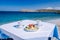 Plaka Lassithi with is traditional blue table and chairs and the beach in Crete Greece