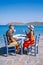 Plaka Lassithi with is traditional blue table and chairs and the beach in Crete Greece