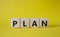 Plan symbol. Concept word Plan on wooden cubes. Beautiful yellow background. Business and Plan concept. Copy space