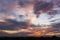 Plane ascending among sumptuous sunset lit stratocumulus and altocumulus clouds