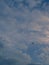 Plane crosses a blue cloudy sky