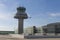 A plane flies next to the control tower at Barcelona Airport, Sp