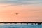 The plane flies to the airport over the river in the city of Faro in Portugal. silhouettes of airplanes and airport, boats in the