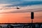 The plane flies to the airport over the river in the city of Faro in Portugal. silhouettes of airplanes and airport, boats in the