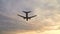 Plane flying overhead in sunset cloudy sky. Aircraft landing in evening slowmo