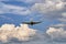 Plane front bottom view with towed glider on cloudy blue sky