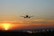 Plane lands at an airfield on the background of sunset