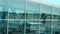 Plane parked by boarding walkway and airport area reflected in terminal windows
