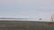 Plane is preparing to land along runway in winter. Stock footage. Plane on runway in winter snowy weather on cloudy