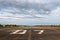 Plane runway, airstrip in the airport terminal with marking on blue sky with clouds to use as background. Travel