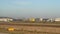 Plane slowly moves along the runway against the background of buildings