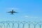 Plane taking off over the barbed wire