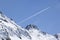 Plane trail over snowy mountain