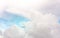 A plane traveling on beautiful white fluffy clouds under vivid and bright blue pastel sky in a suny day