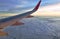 Plane wing and cloud floating on sky through window frame on sunset