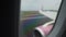 Plane wing and engine seen through rainy window during shaky landing on runway