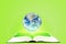 Planet earth globe floating over opened book with green background. Elements of this image furnished by NASA.