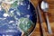 The planet Earth plate with a fork and knife on a wooden background. World hunger concept. Feed the world